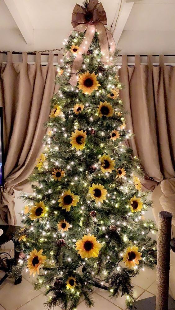 a sunflower Thanksgiving tree with lights, pinecones, blooms and a large taupe bow on top
