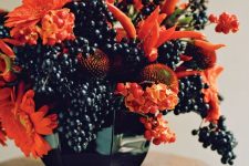 a very sumptuous floral arrangement for Halloween of orange blooms, berries and peppers looks fantastic