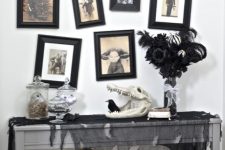 a vintage Halloween console table with black tulle, skulls and black roses plus a gallery wall with scary pics