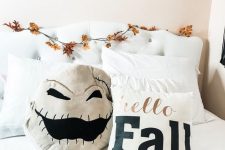 add a scary pillow, a spiked pumpkin and a moon phase garland over the bed to make your bedroom more Halloween-like