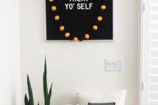 minimalist Halloween styling with a black sign and orange pompoms, white and orange pumpkins