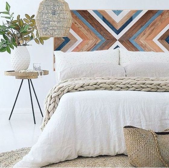 a painted wooden headboard with a chevron pattern, a wicker lampshade and a jute rug for a boho meets rustic feel