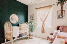 05 a welcoming gender neutral nursery with a boho rug, a dark green statement wall, a burlap curtain and greenery