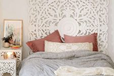 06 a white headboard made of an ornate wooden screen and matching nightstands