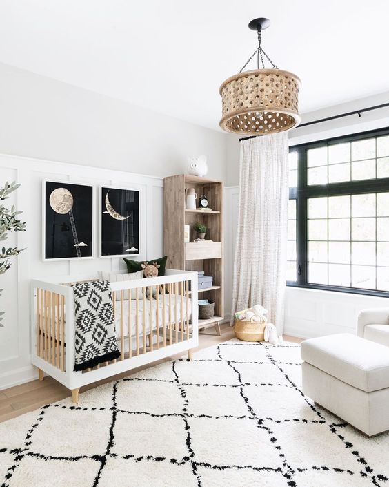 a catchy neutral nursery with touches of black for drama, prints, a wooden lamp and furniture
