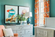 10 a colorful gender neutral nursery done in turquoise and orange, with white furniture, an orange chair and a leather ottoman plus bold artworks