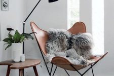 11 a brown leather butterfly chair, a stylish floor lamp and a cutout table for a chic Scandinavian reading nook