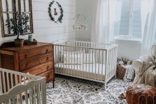 13 a boho farmhouse nursery with stained furniture, a boho rug and some vintage touches