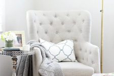 14 a grey tufted chair, a printed footrest, a floor lamp and a vintage refined side table for a chic reading nook