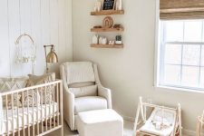 18 a farmhouse neutral nursery with light-colored furniture, a boho rug, a woven lamp and wooden furniture