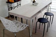 18 a whitewashed pallet dining table with a tabletop of a single pallet and thin metal legs on casters