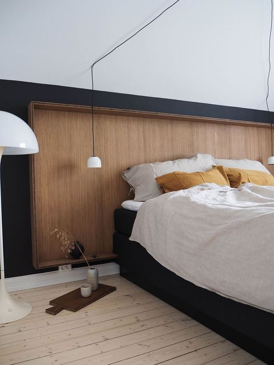 a sleek wooden headboard with a frame matches this Scandinavian bedroom and brings coziness and warmth here