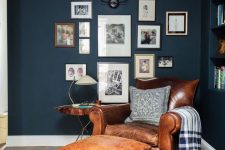 23 a traditional brown leather chair and a footrest, a gallery wall and a table lamp for a timelessly cozy reading nook