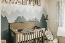 23 an adventuruous nursery with a mountain accent wall and a baby’s name on the wall