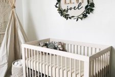 25 the name placed on the wall and accented with a fake greenery wreath is a stylish idea for a gender-neutral nursery