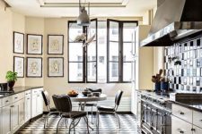 a bold kitchen in black and white, with a tiled floor, a tiled backsplash, blakc chairs and a round table, metal pendant lamps