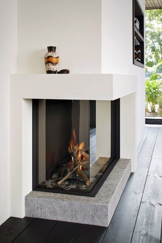 a built-in fireplace with a glass cover and a stone base is a beautiful and cool idea for a contemporary space