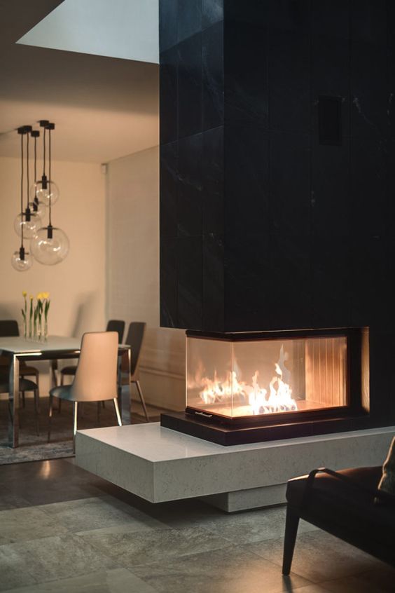 a contemporary built-in fireplace with a sleek black tile top and a light-colored stone base is a bold contrasting idea to rock