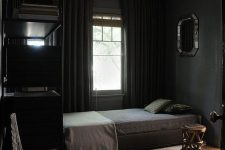 a dark vintage bedroom with black walls, black furniture and curtains, a wooden stool and a mirror on the wall