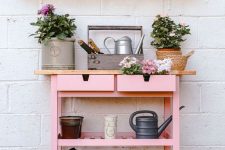 a gardening station of an IKEA Forhoja cart with pink paint and a light-stained countertop is super cute