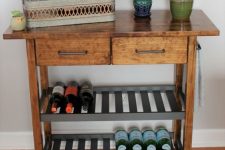 a mid-century modern IKEA Forhoja cart hack with dark stain, a butcherblock countertop and dark shelves as a drink cart