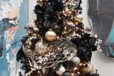 02 a black Christmas tree decorated in gold and silver for a chic gothic-inspired look, with faux crow birds and berry branches