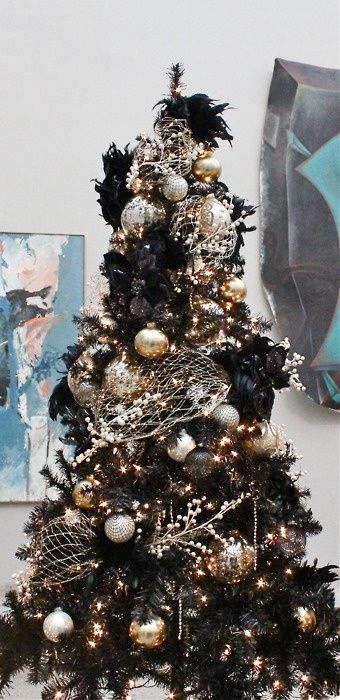 a black Christmas tree decorated in gold and silver for a chic gothic inspired look, with faux crow birds and berry branches