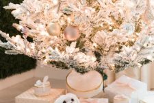 02 a flocked Christmas tree with shiny metallic, glitter and pastel ornaments, lots of white and blush gift boxes and a white dog