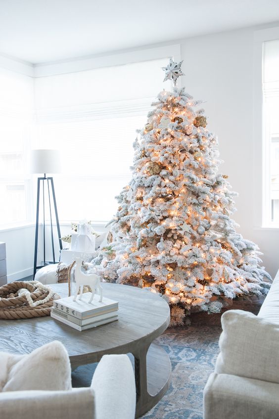 a flocked Christmas tree with matching white and silver ornaments, pinecones and lights is a lovely idea for Christmas