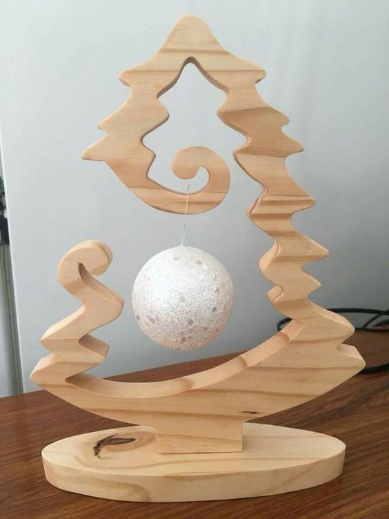 a carved out wooden tabletop Christmas tree with a single ornament hanging inside is a very cool idea for holidays