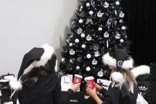 07 a black Christmas tree with white ornaments, snowlfkaes and ribbons and some lights is a lovely and chic idea