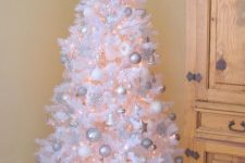 08 a white Christmas tree with lights, silver, white and shiny silver ornaments, a shiny star topper and some letters is wonderful