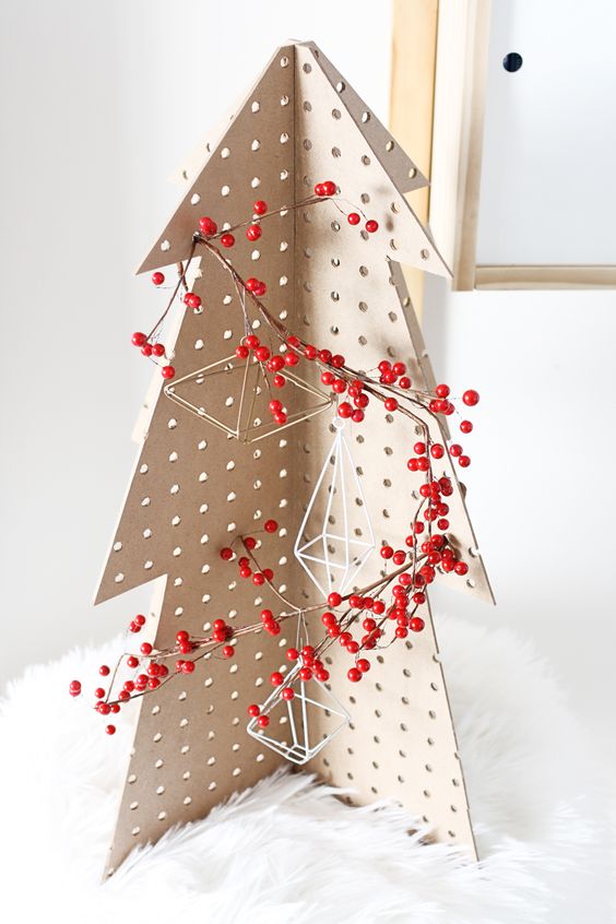 a pegboard Christmas tree decorated with himmeli ornaments and berries placed on faux fur is a great tabletop idea