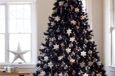 10 a chic black Christmas tree with sheer ornaments and white snowflakes plus a fabric cover on top plus piles of gifts is a lovely idea