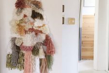 11 a creative tassel, pompom and yarn Christmas tree on the wall is a nice alternative for a boho space, if you don’t have a nook for a real tree