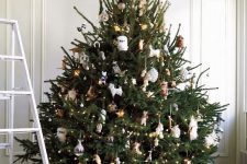 11 a stylish Christmas tree decorated with lights, with gold and white ornaments and feathers looks cool and wild