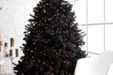 12 a pre-lit black Christmas tree with piles of gifts is a lovely and bold idea for a modern space – who needs decor when you have lights