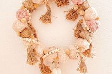 14 a beautiful pastel boho Christmas wreath of pompoms, tassels, wooden beads and a larger tassel piece as an accent