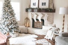 14 a chic white Christmas living room with a flocked Christmas tree, pompoms, white stockings, faux fur and pillows