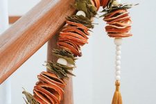 15 a dried citrus garland with leaves and beads plus a mustard tassel on the end is a cool natural and boho decor idea