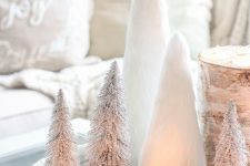 15 a gorgeous white tray with a tree stump with candles, white candles, mini tabletop Christmas trees is a chic centerpiece or decoration