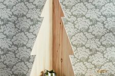 16 a plywood Christmas tree with candles around and colorful gifts next to it is a simple and modern idea to try