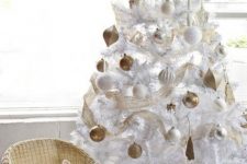 16 a white Christmas tree decorated with white and gold ornaments, with gold ribbons is ultimate chic and elegance