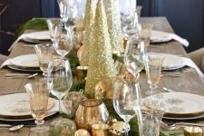 17 a chic holiday table decorated with gold glitter Christmas trees and metallic candleholders, white porcelain with gold snowflakes is beautiful