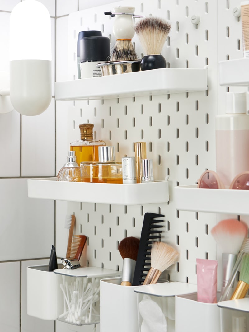 a Skadis pegboard used to store accessories and makeup in a bathroom, this pegboard isn't only for offices, it's for everything