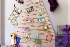 20 a simple plywood Christmas tree decorated with yarn and vintage Christmas cards plus stockings around is a very eco-friendly idea