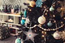 21 a black Christmas tree with lights, silver and tiffany blue ornaments, snowflakes of various sizes and shiny mini wreaths is chic