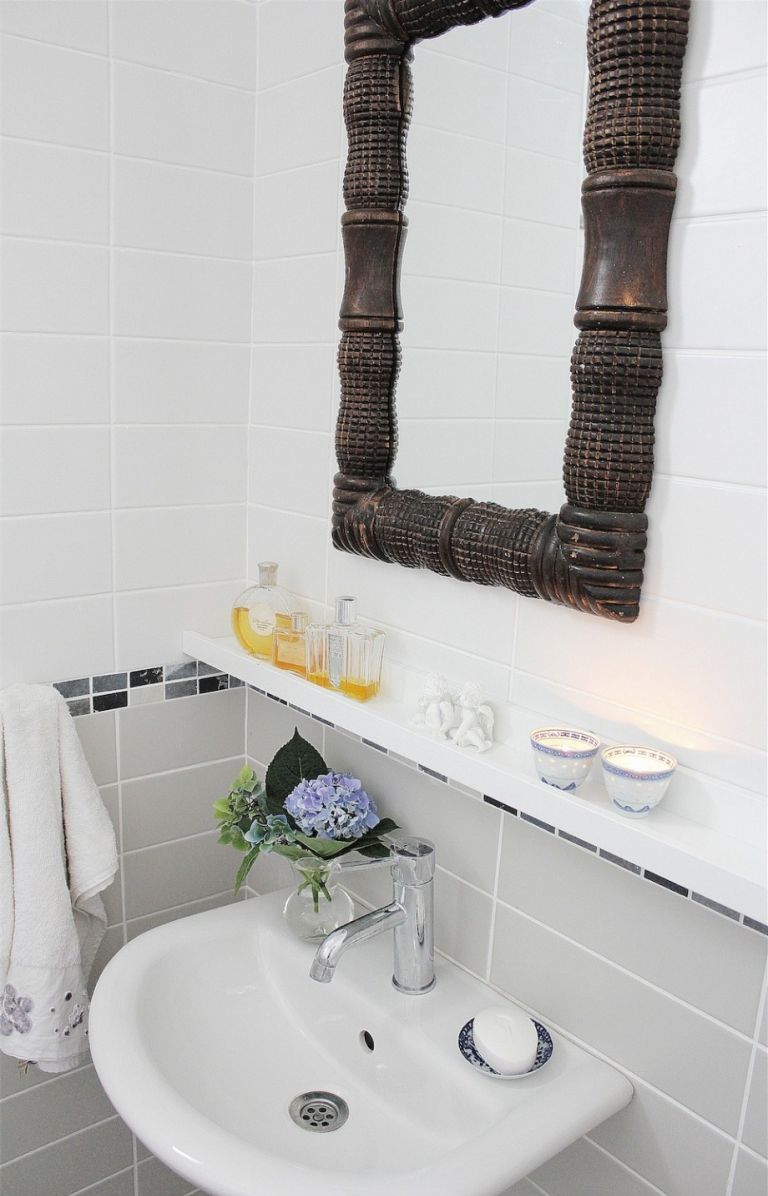 IKEA's slender picture ledges used to add some storage over the sink, a genius idea for a small bathroom like this one
