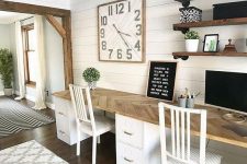 a beautiful rustic home office with a shared desk, open shelves, an oversized clock and a bold artwork is a welcoming space