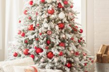 a bold modern flocked Christmas tree with red and white ornaments of various sizes is a chic idea